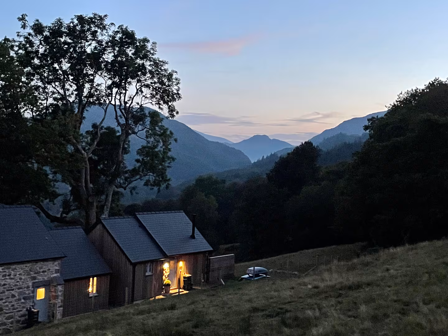 The Bothy at night — warm lit windows against the dark valley