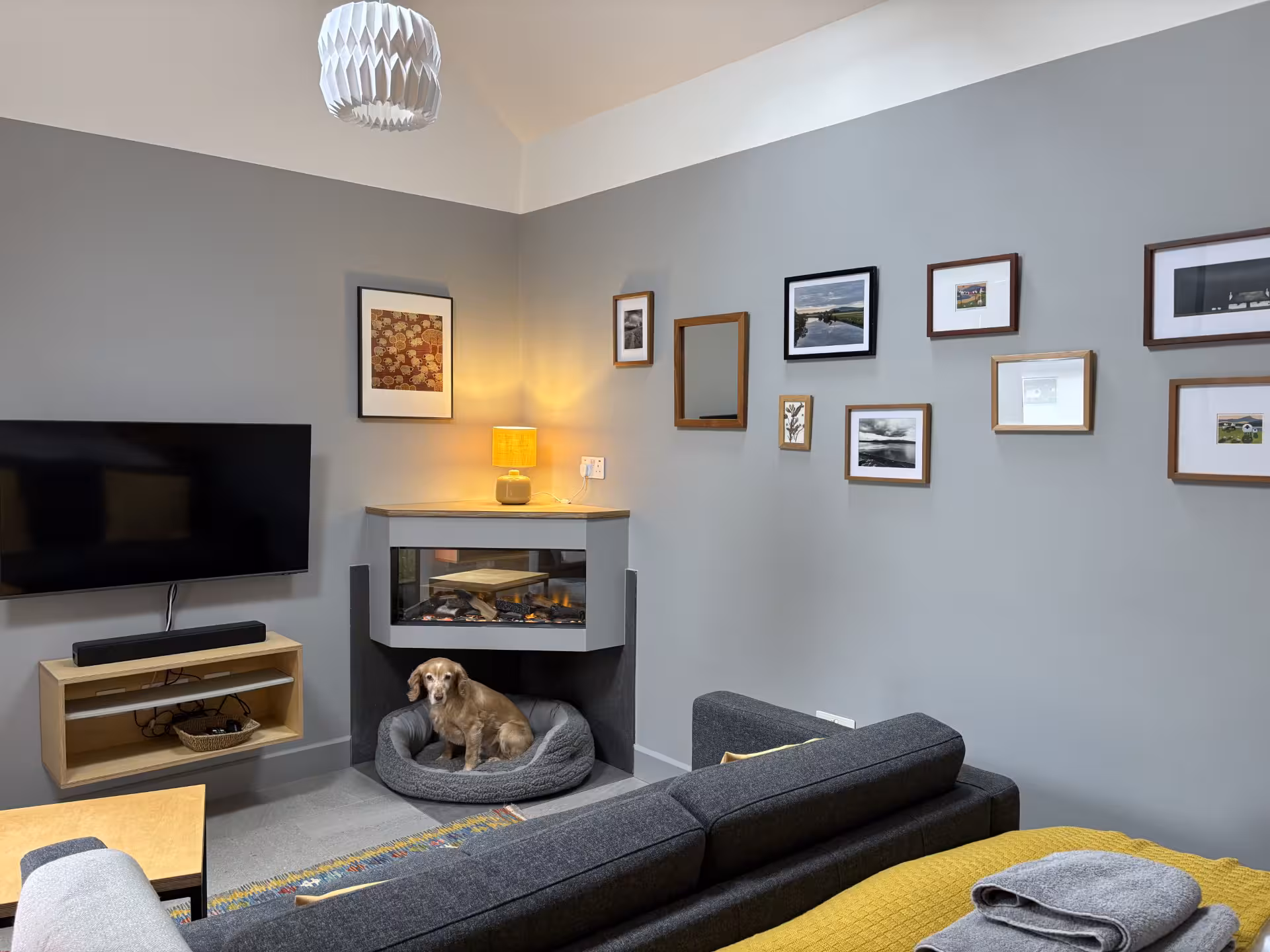 Open-plan living area at The Wheelhouse with sofa, fireplace and superking bed